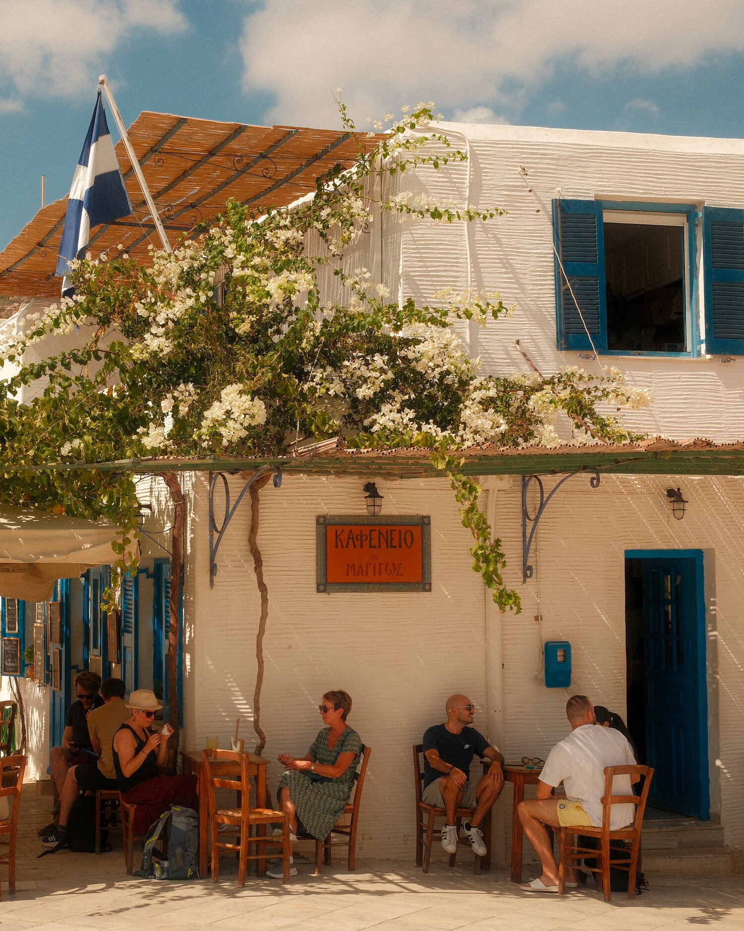 Kafeneio terrace under white bougainvillea