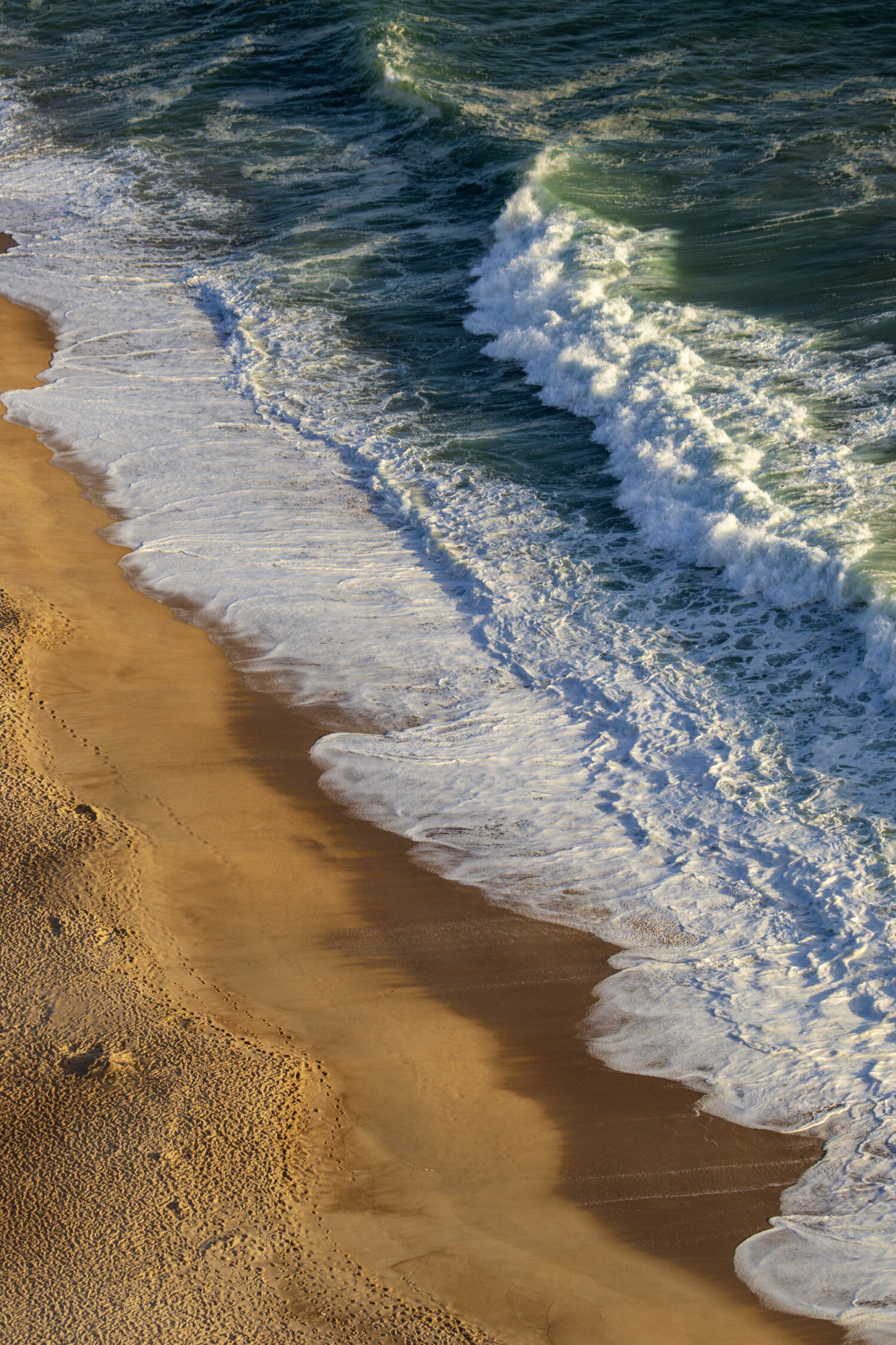 Abendliche Brandung im Sand von Nazaré