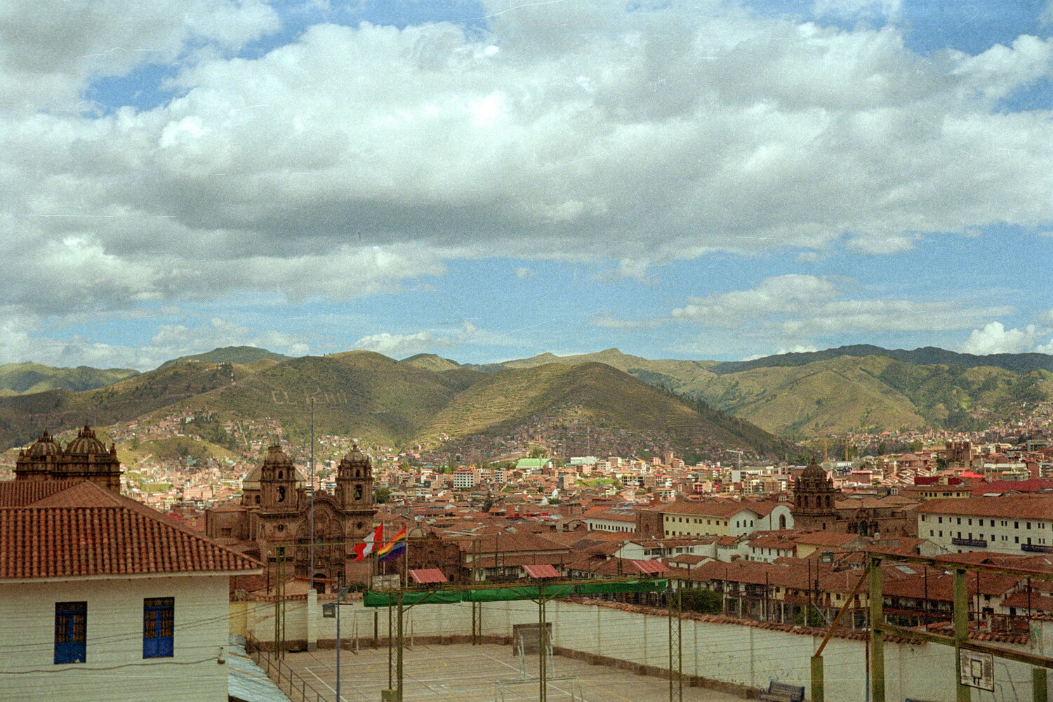 Terrakottadächer von Cusco unter grünen Hügeln