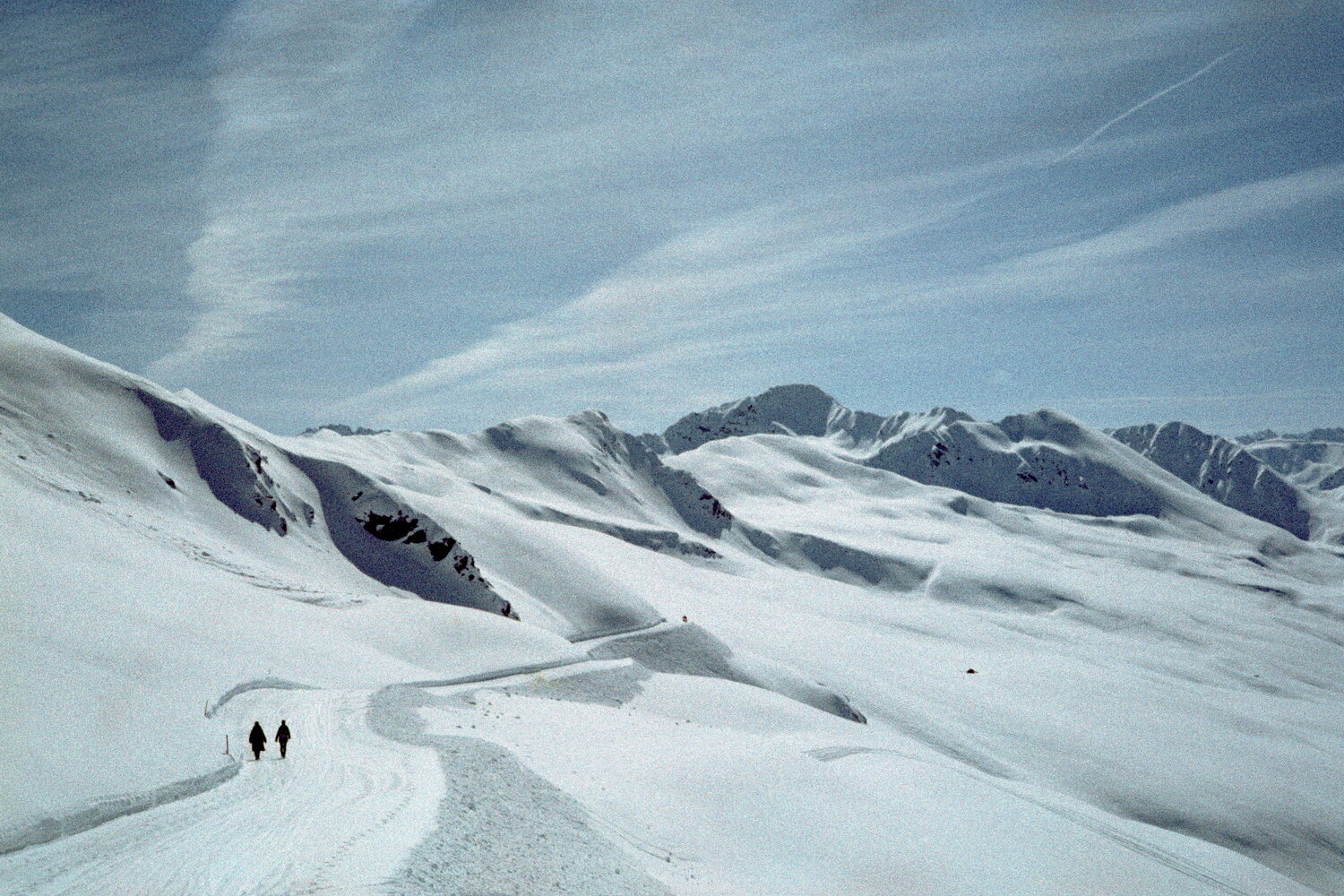Two walkers on a snowy trail near Davos