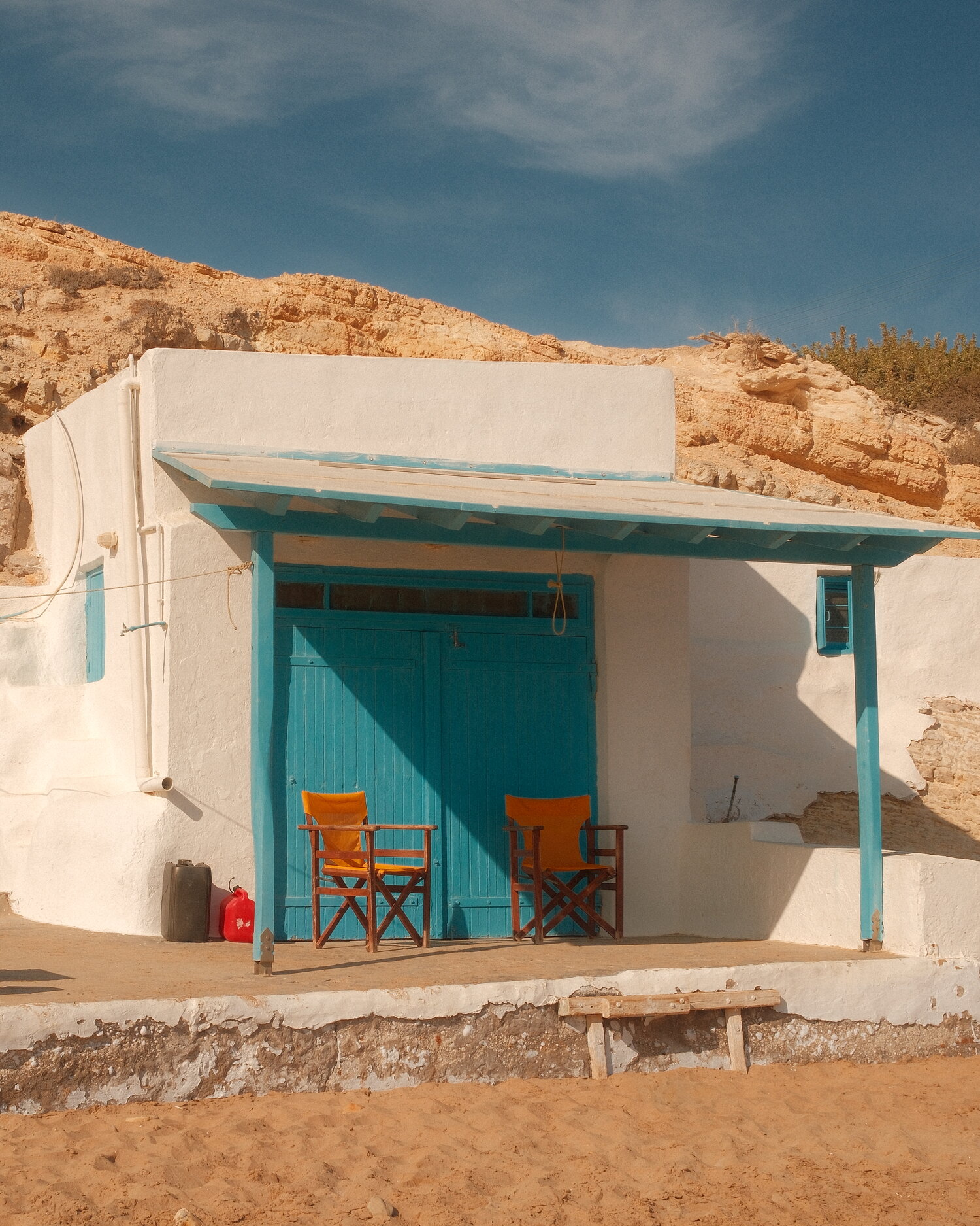 Türkisfarbene Türen eines Hauses im Sand