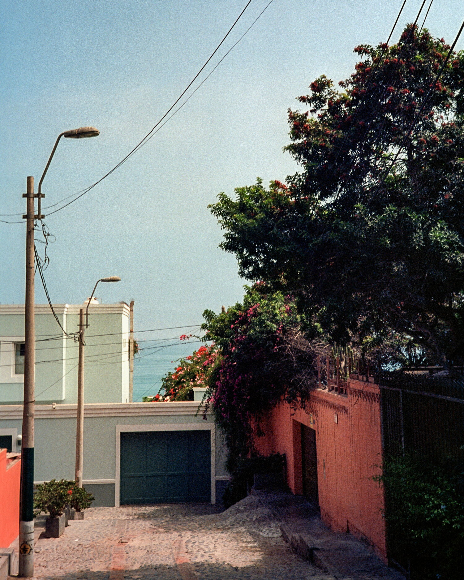 A cobbled lane ending in a strip of ocean