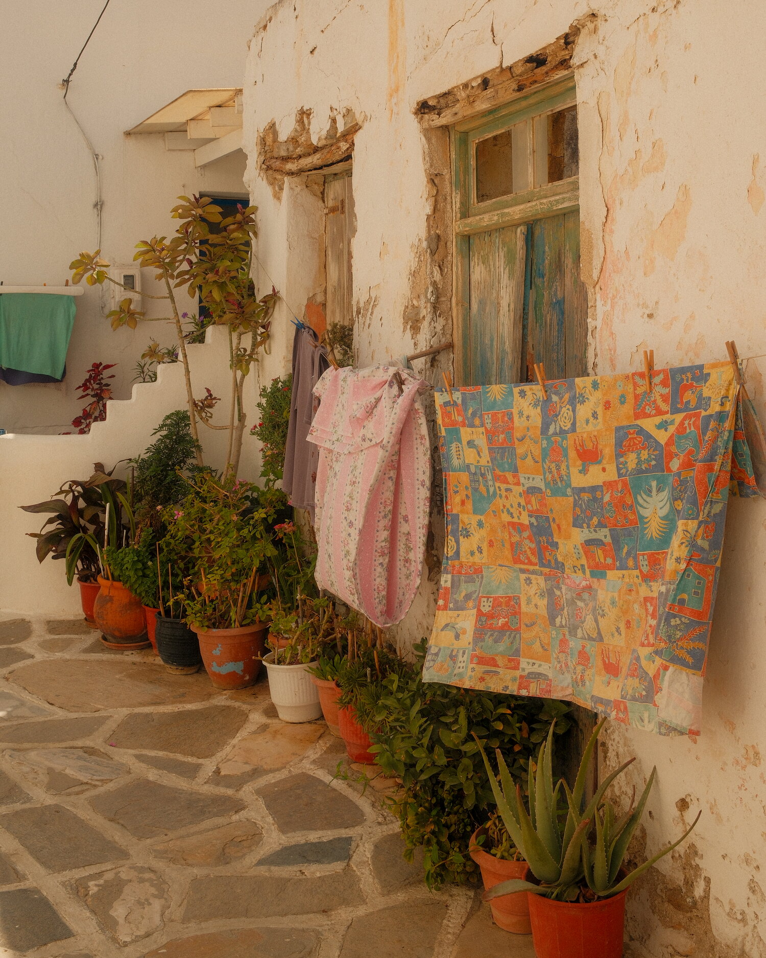 Laundry and potted plants in a Paros lane