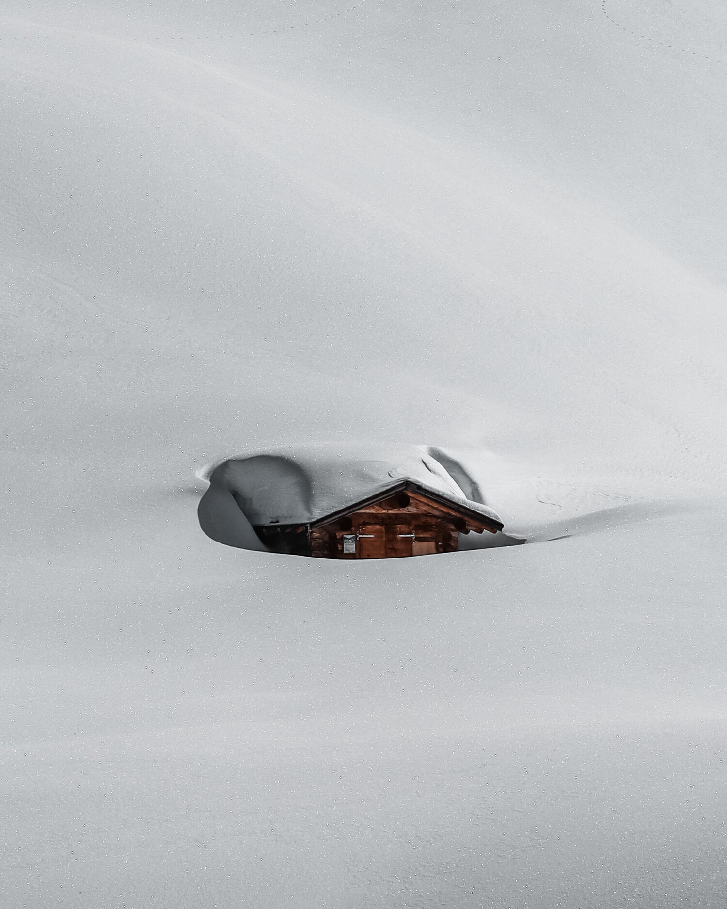 Holzhütte unter tiefem Schnee