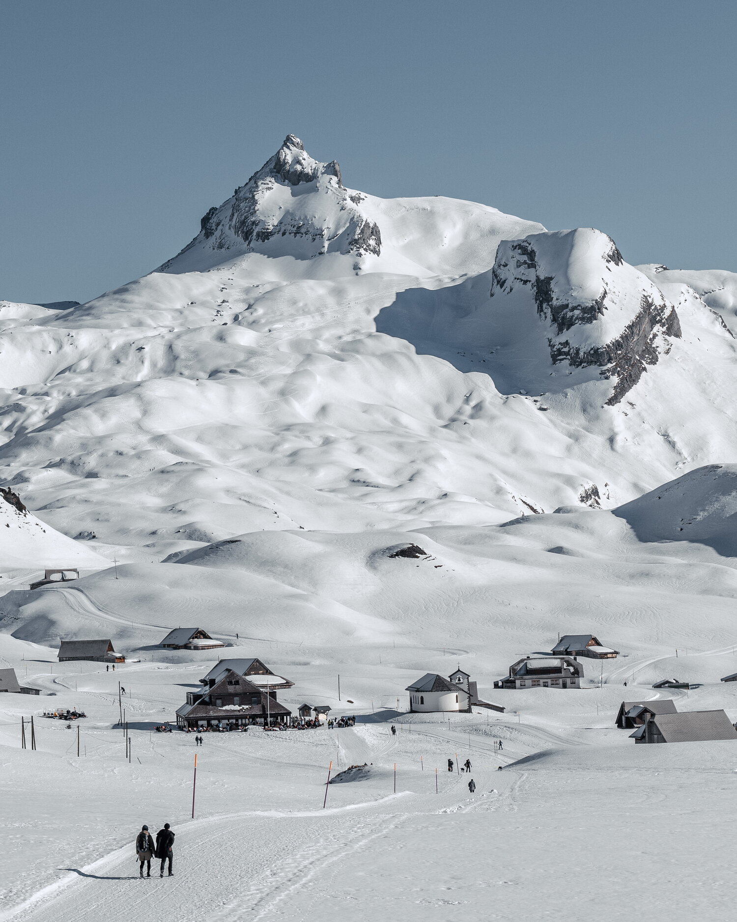 Two walkers heading for a snowbound hamlet