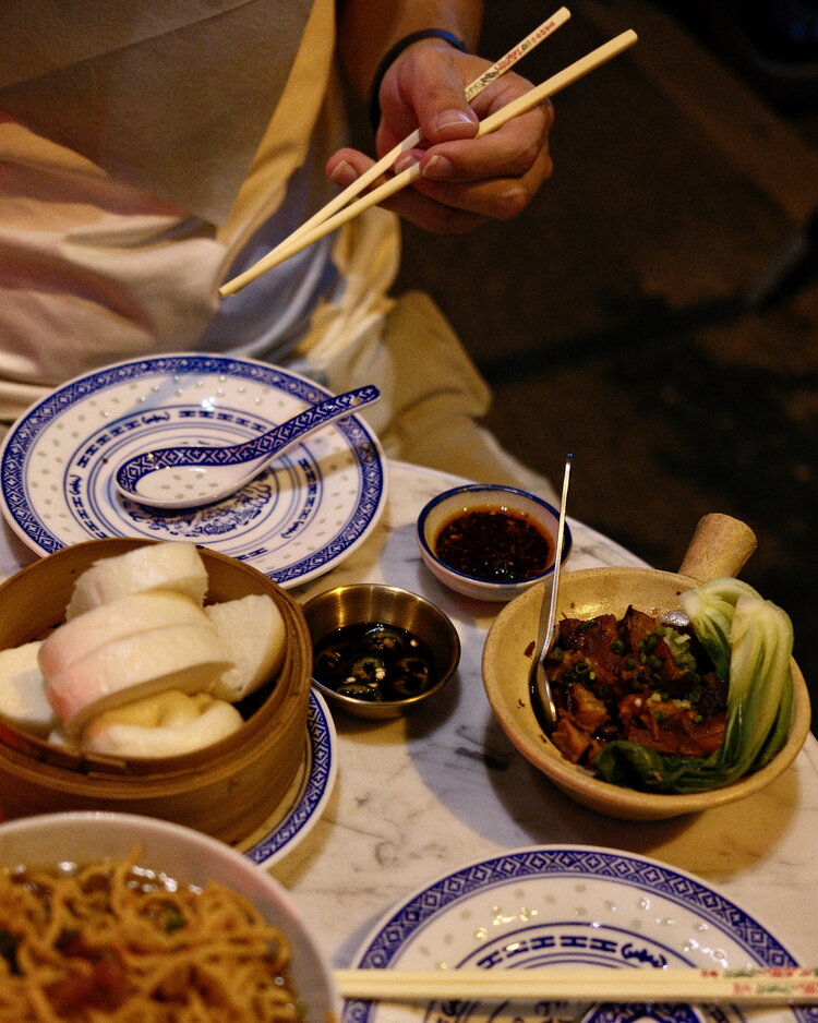 Dim sum, fideos y salsas en una mesa puesta